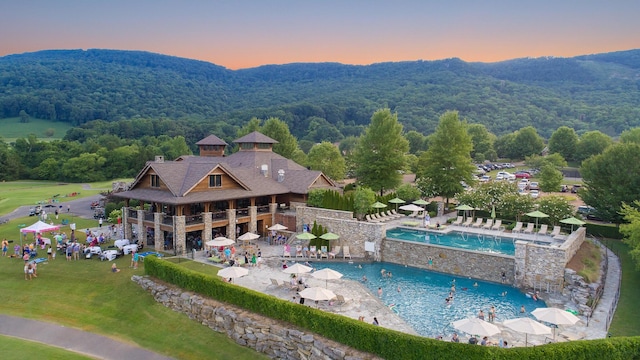 aerial view at dusk with a mountain view and a wooded view