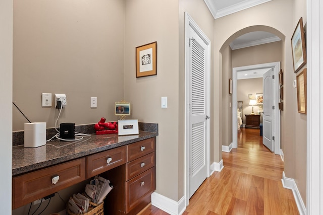 bathroom with baseboards, ornamental molding, wood finished floors, and vanity