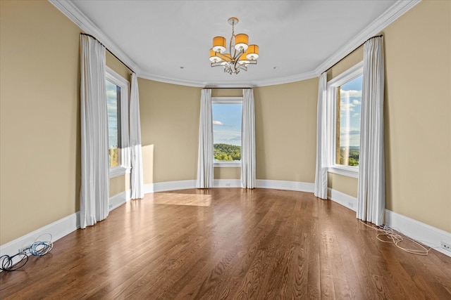 spare room featuring a healthy amount of sunlight, ornamental molding, and wood finished floors