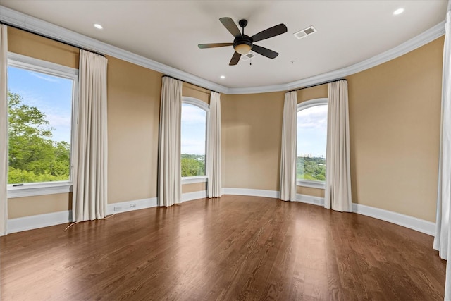 spare room with visible vents, crown molding, baseboards, and wood finished floors