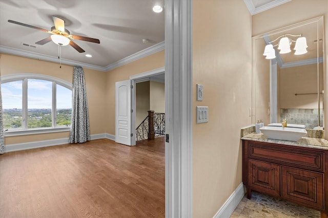 bathroom with baseboards, wood finished floors, and crown molding