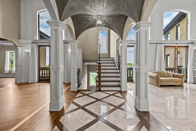 foyer with arched walkways, baseboards, stairs, marble finish floor, and decorative columns