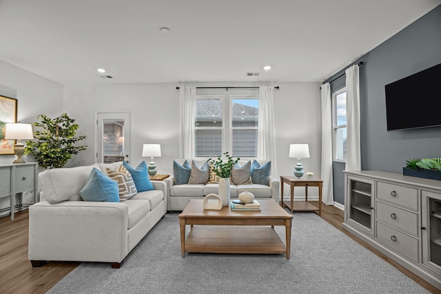 living room featuring recessed lighting, visible vents, and wood finished floors