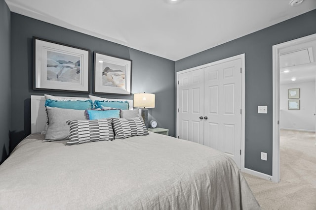 carpeted bedroom featuring baseboards and a closet