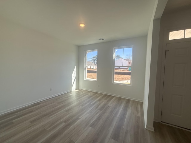 entryway with wood finished floors, visible vents, and baseboards