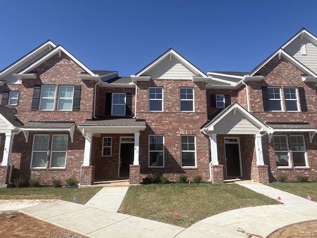 view of front facade with a front lawn and brick siding