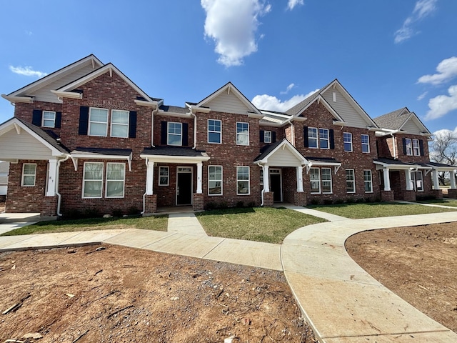 view of front of house with a front lawn and brick siding