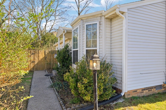 view of home's exterior with crawl space and fence