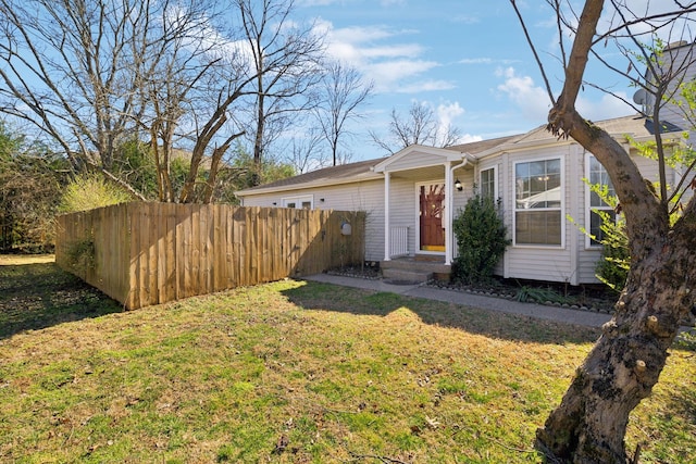 view of front facade featuring fence and a front lawn