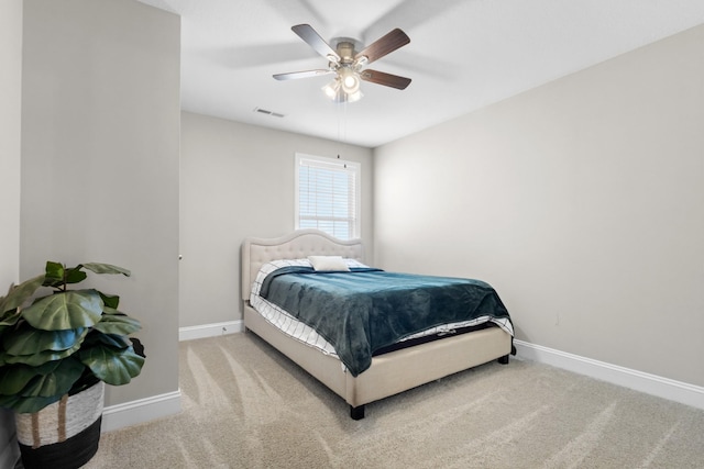 carpeted bedroom featuring ceiling fan, visible vents, and baseboards