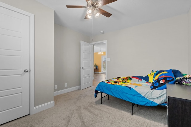 carpeted bedroom featuring ceiling fan and baseboards