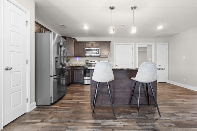 kitchen featuring visible vents, dark wood finished floors, a kitchen island, appliances with stainless steel finishes, and dark brown cabinets