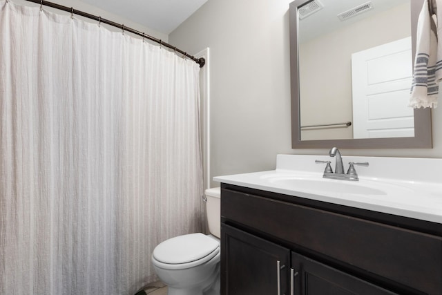 full bathroom featuring toilet, vanity, and visible vents