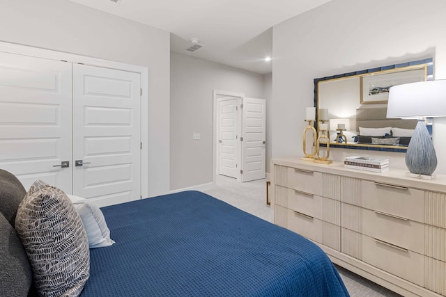 bedroom featuring light colored carpet, a closet, visible vents, and baseboards