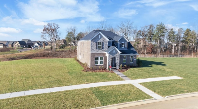 traditional-style home with a residential view, a front lawn, and brick siding