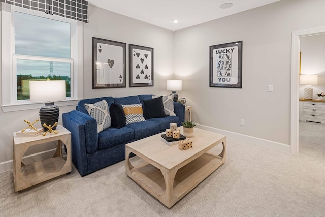 living area with light carpet and baseboards