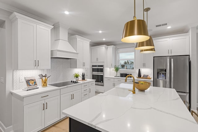 kitchen featuring white cabinets, custom range hood, and stainless steel appliances