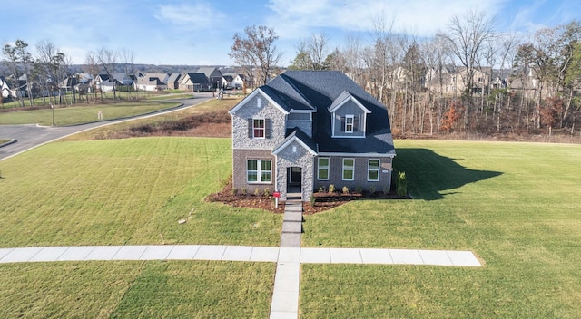 traditional home with a front yard, stone siding, brick siding, and a residential view