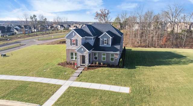 traditional home featuring a front yard, stone siding, brick siding, and a residential view