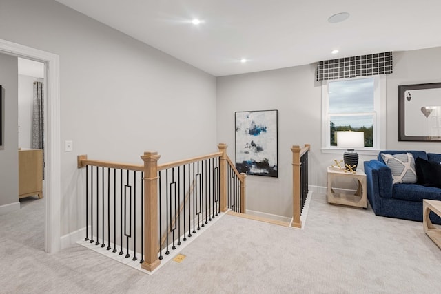 corridor featuring carpet floors, recessed lighting, baseboards, and an upstairs landing