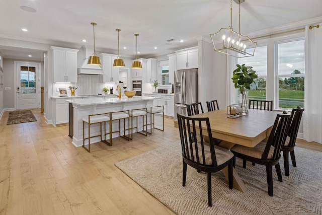 dining room with ornamental molding, recessed lighting, baseboards, and light wood finished floors