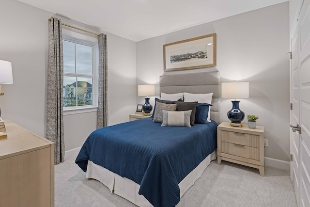 bedroom with light carpet and baseboards