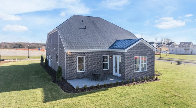 exterior space with brick siding, a shingled roof, a lawn, and a patio