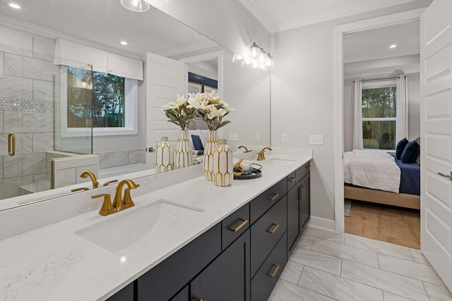 bathroom featuring double vanity, a stall shower, crown molding, and a sink