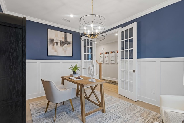 office featuring a chandelier, wood finished floors, visible vents, french doors, and crown molding