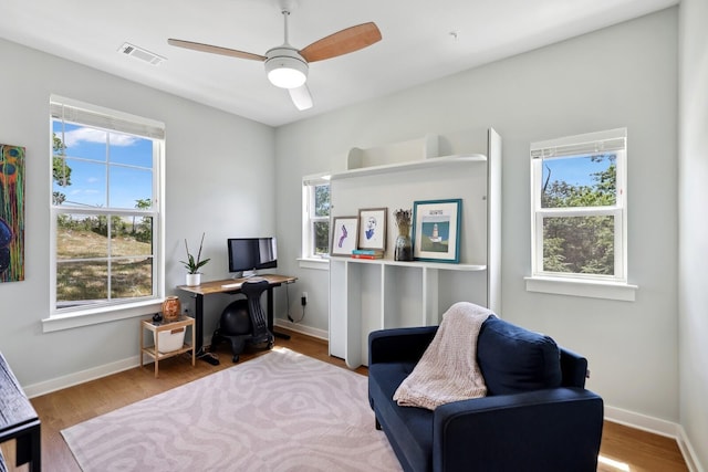 office area with ceiling fan, wood finished floors, visible vents, and baseboards