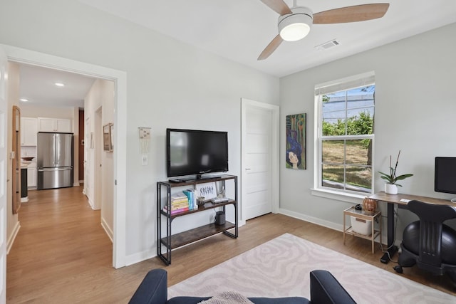 living area featuring light wood-type flooring, visible vents, ceiling fan, and baseboards