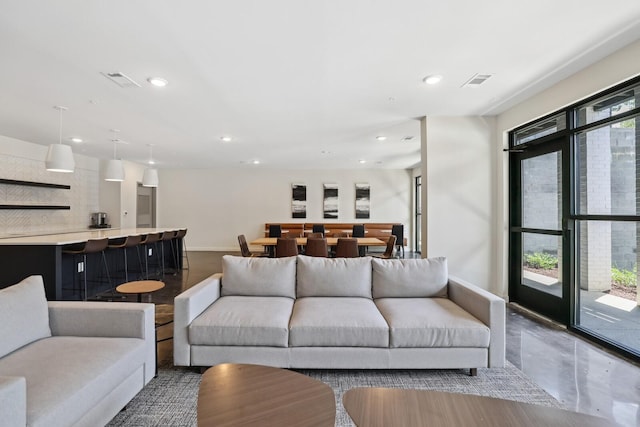 living room with baseboards, visible vents, and recessed lighting