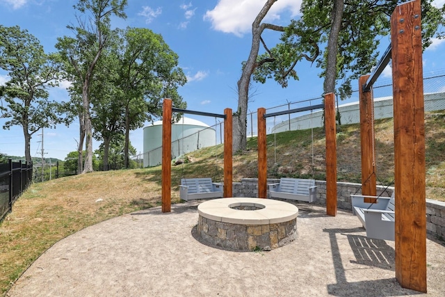 view of patio featuring an outdoor fire pit and fence