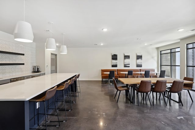 dining area featuring finished concrete floors, baseboards, and recessed lighting