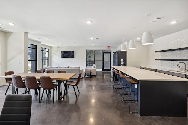 dining room with finished concrete flooring, visible vents, and recessed lighting