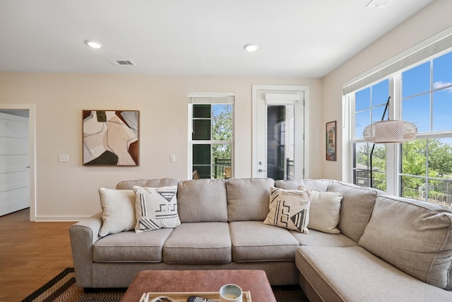 living room featuring baseboards, wood finished floors, visible vents, and recessed lighting