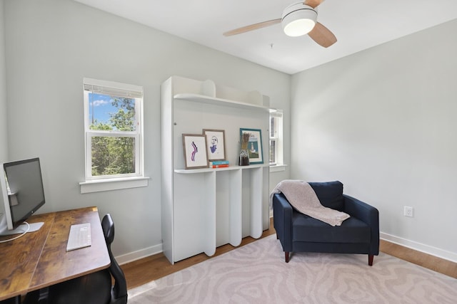 office featuring baseboards, a ceiling fan, and wood finished floors