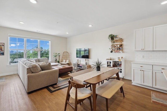 dining space featuring baseboards, light wood-style flooring, and recessed lighting