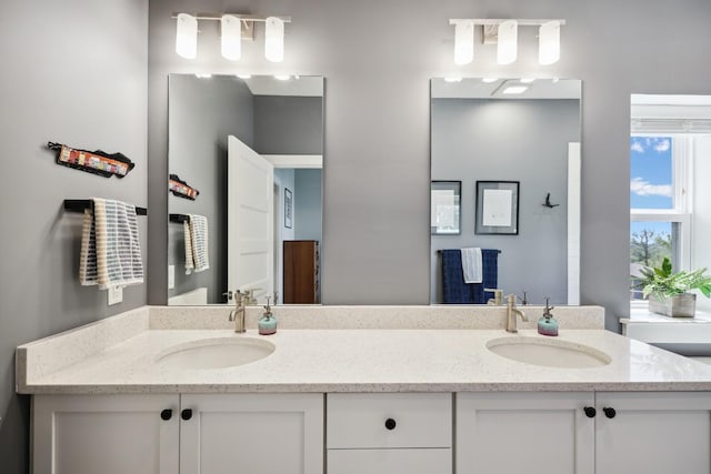 full bathroom with a sink and double vanity