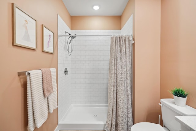 bathroom featuring a shower stall and toilet