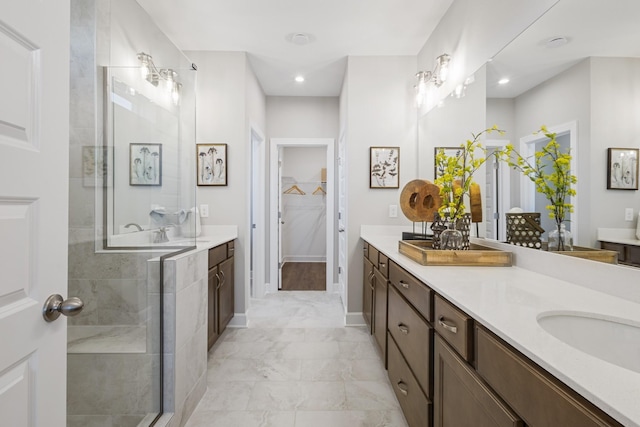 full bathroom with marble finish floor, tiled shower, vanity, and baseboards