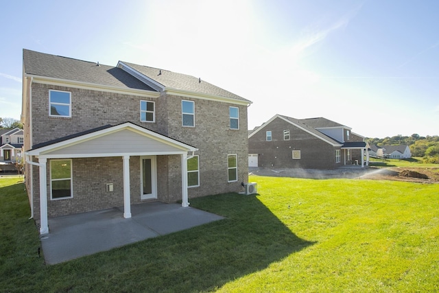 rear view of house featuring a yard, a patio area, and brick siding