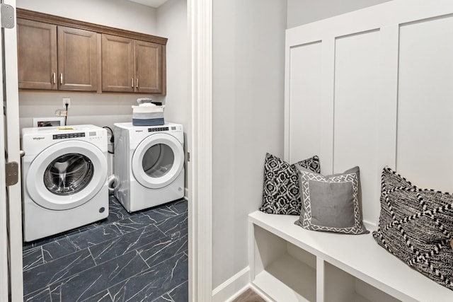 laundry area with marble finish floor, washing machine and clothes dryer, cabinet space, and baseboards