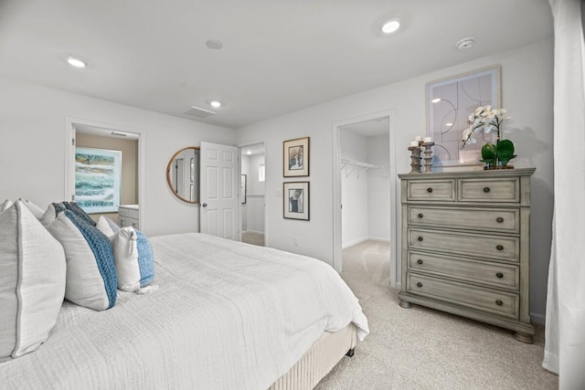 bedroom featuring recessed lighting, a spacious closet, a closet, and light colored carpet