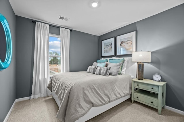 bedroom with baseboards, visible vents, and light colored carpet