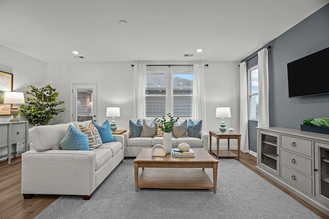 living room with wood finished floors, visible vents, and recessed lighting