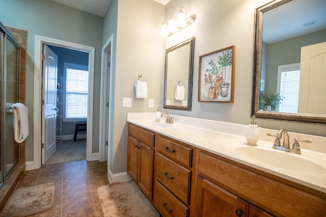 full bathroom with a stall shower, tile patterned flooring, a sink, and double vanity