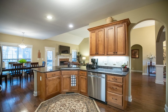 kitchen with brown cabinetry, dark wood-type flooring, a peninsula, and stainless steel dishwasher