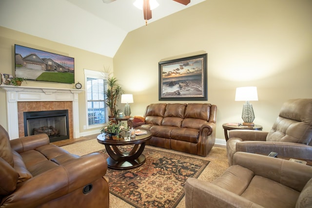 living area with a ceiling fan, lofted ceiling, baseboards, and a tile fireplace