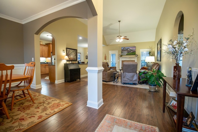 foyer with crown molding, a fireplace, decorative columns, dark wood-type flooring, and ceiling fan